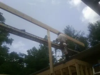 Carpenter setting a ridge beam over a new addition frame — Ice Dam Removal by Roofing Brothers in Lacon