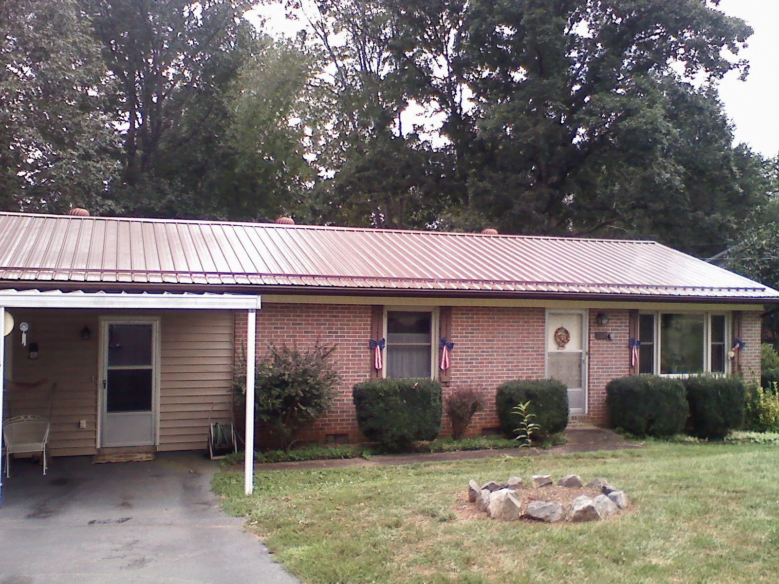 Bronze metal roof and carport on a brick ranch home — Roof Repair work by our crew in Lacon