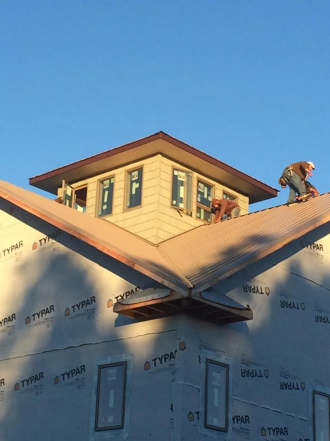Roofers working around a rooftop cupola on a new metal roof at sunset — Roof Waterproofing in Lacon by Roofing Brothers
